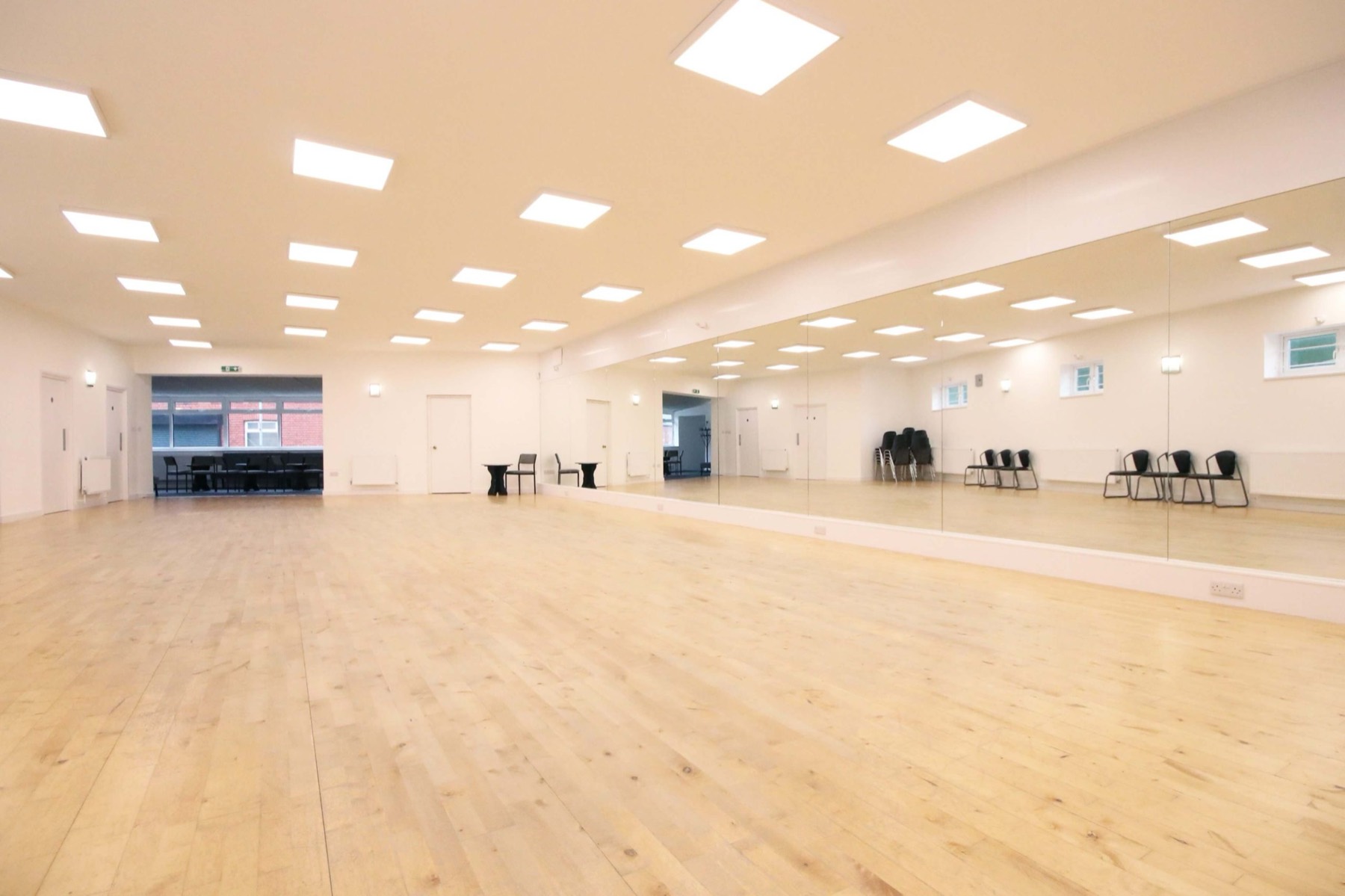 The BDC Studio hall: a long, bright wooden floor with LED ceiling panels and a full mirrored wall
